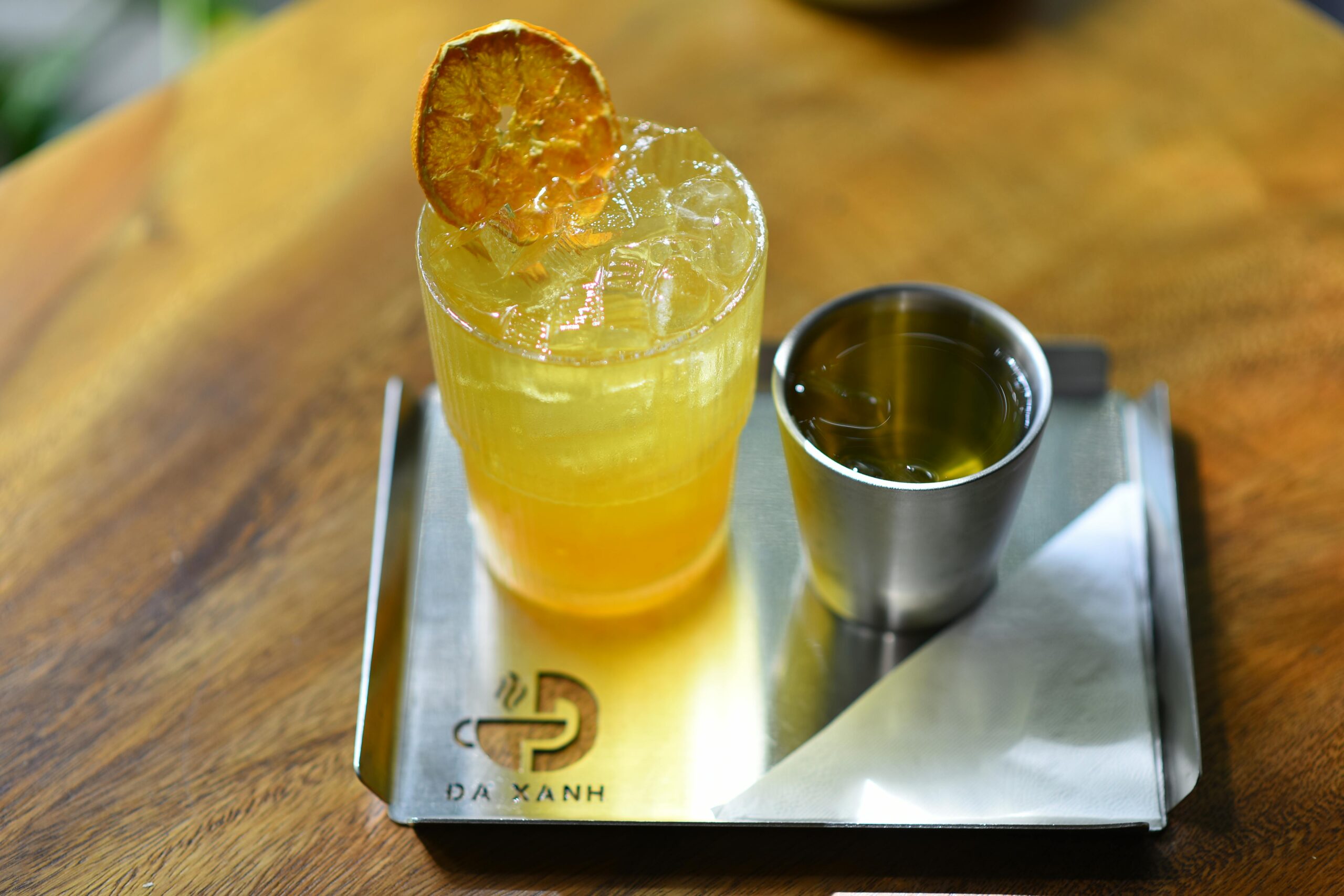 A refreshing citrus drink with a slice of dried orange and a cup of iced tea.